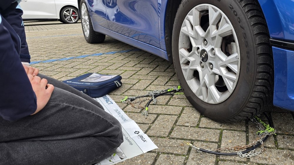 Leg de ketting achter het wiel.